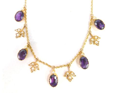 An Edwardian amethyst and seed pearl pendant, set with five oval amethysts and four three point leaves, each set with seed pe