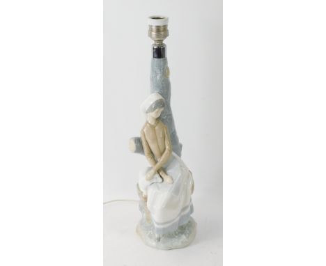 A Nao porcelain table lamp, depicting a lady with a lamb on tree branch, 41cm high.