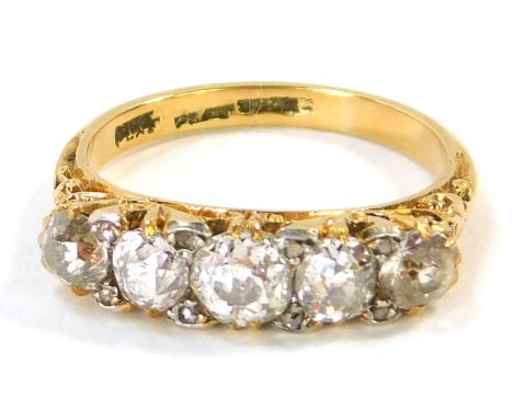 An 18ct gold and platinum diamond five stone dress ring, set with five old cut diamonds, each in claw setting, with scroll de