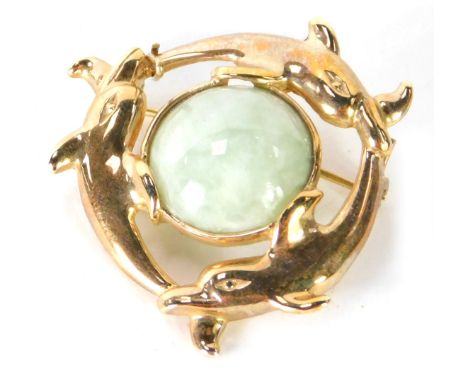 A jade brooch, with outer row of three dolphins and light green jadite centre, in yellow metal frame, unmarked, believed to b