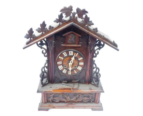 A 19thC Black Forest pine mantel clock, the arched top with vine and berry detail, with bone Roman numeral markers, and hands