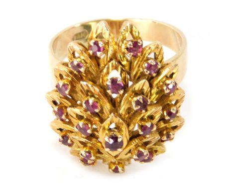 A ruby layered dress ring, the central leaf brushed design with ruby centre in claw setting, on a raised basket on plain band