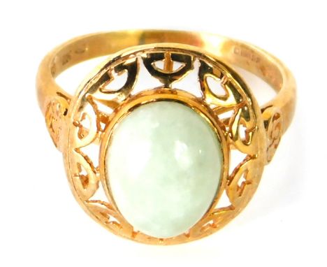 A 9ct gold jade dress ring, with cabouchon cut oval light jade stone, pierced design border, with V splayed shoulders, size N