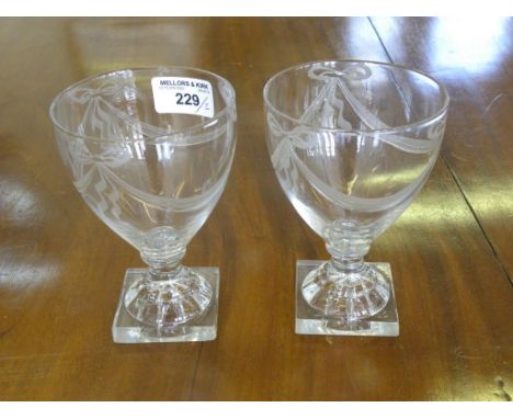 A PAIR OF GLASS RUMMERS, THE BOWL ENGRAVED WITH SWAGS, ON MOULDED 'LEMON SQUEEZER' FOOT