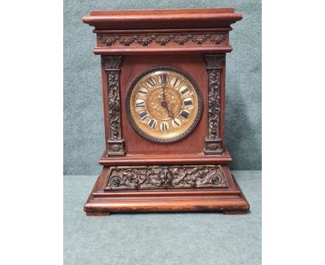 Victorian mahogany mantle clock decorated with Lions mask and musical columns with brass embossed cherub dial by the British 