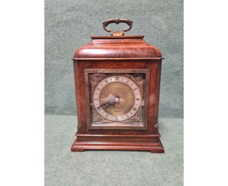 Burr walnut Eliot mantle clock with silvered dial and brass cherub spandrels.