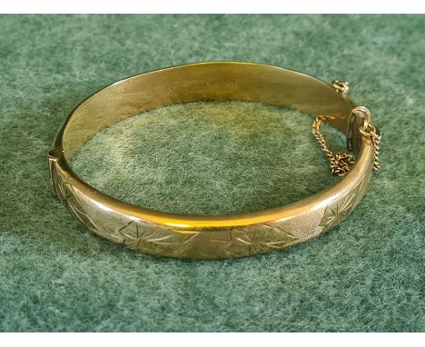 9ct gold hinge bangle with engraved leaf decoration, 12.8g.