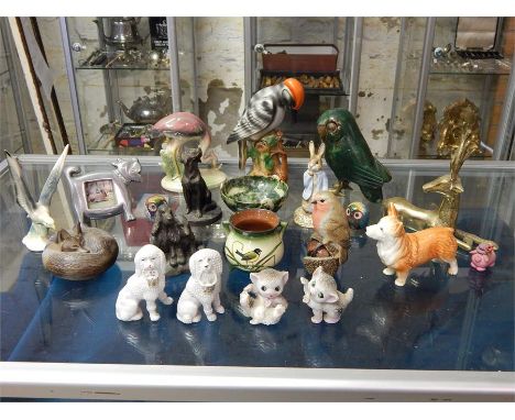 A selection of animal figurines in wood, china and metal mainly birds and dogs including a Peter Rabbit figurine by 1990 Roya