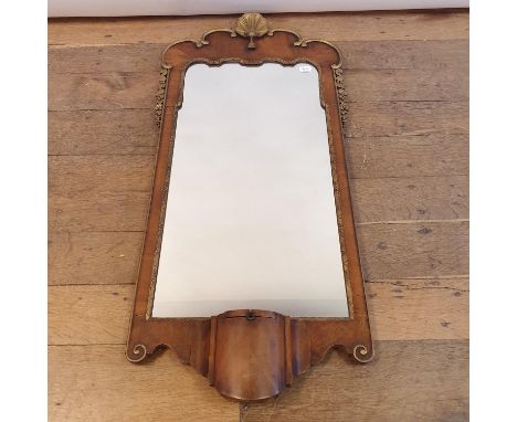 A George III style walnut and giltwood wall mirror, with a shell finial, and base with candle stand, 102 x 48 cm 