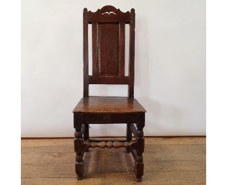 An 18th century oak high back chair, with a panel back and seat, 104 cm high 