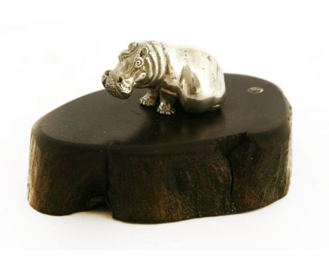 A contemporary silver sculpture of a seated hippo, by Patrick Mavros, Zimbabwe,on a naturalistically carved ebony base, inset