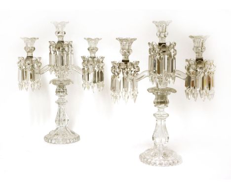 A pair of Baccarat crystal three-branch candelabra,20th century, each with three flower head sconces, on shaped arms, knopped