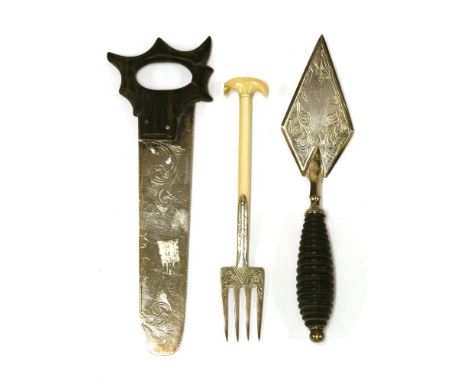 An electroplated cheese saw,with a lignum vitae handle,a miniature trowel,together with an ivory-handled pickle fork,modelled