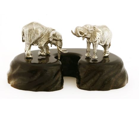 A contemporary silver sculpture of two elephants at a waterhole,by Patrick Mavros, Zimbabwe,on a naturalistically carved ebon