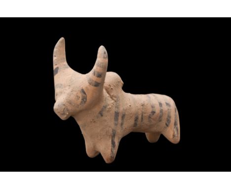 Ca. 3rd millennium BC. A cream-coloured ceramic figurine of a zebu bull with rondel eyes. Painted with stripes on the back, s