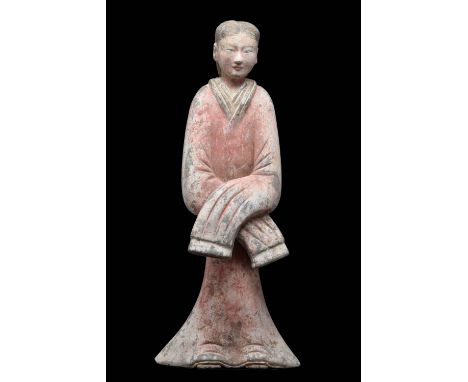 Ca. 206 BC-220 AD. A superb terracotta figure portraying a standing lady of remarkable elegance and poise. The lady's attire 