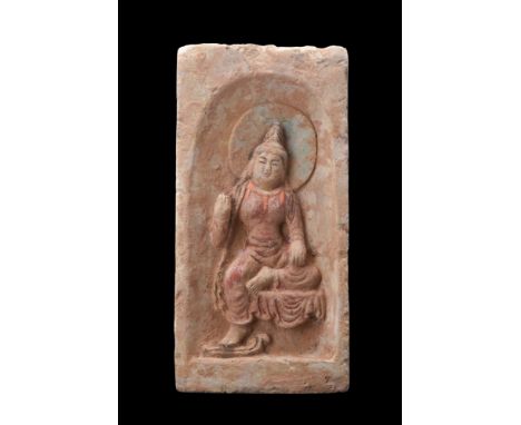 Ca. 386-534 AD. A finely moulded grey pottery tile features Buddha within an arched recess. Buddha sits with his right foot o