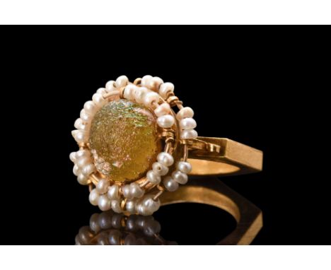 Ca. 600-800 AD. A gold finger ring composed of a hexagonal-shaped hoop with scrollwork decorations to the shoulders. The beze