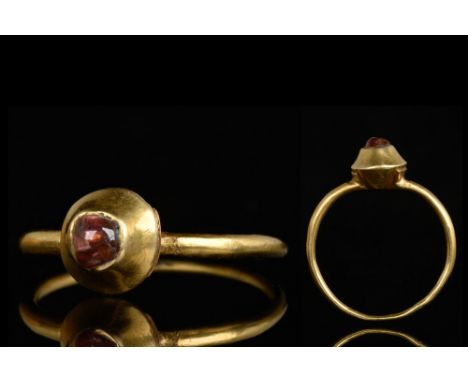 Ca. 1400 AD. A gold ring with a slender round-section hoop, plano-convex bezel with an inset cabochon stone. Cf. Chadour, A.B