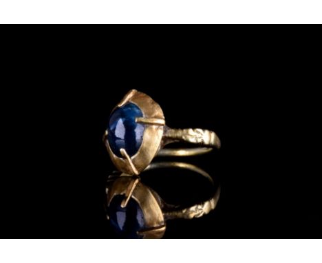 Ca. 1600 AD. A gold thin band with ridged shoulders, a large conical shaped bezel with sapphire, held by four gold planks hol