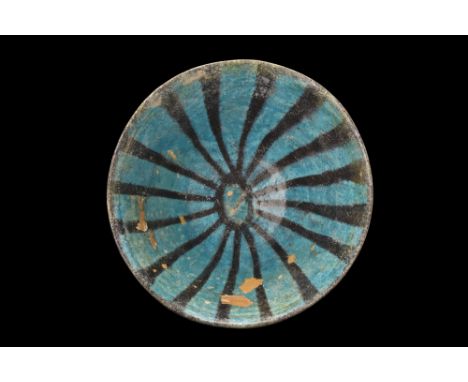 Kashan, Ca. 1100-1200 AD. A pottery bowl with truncated cone-shaped walls, rising from a low ring foot left unglazed. The bod