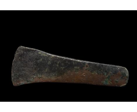 Ca. 1st millennium BC. A flat axe, with a broad, curved cutting edge tapering gently to a rounded butt.Size: L:45mm / W:130mm