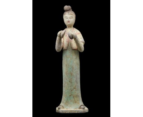 Ca. 618-907 AD. A finely modelled terracotta figure of a female musician playing cymbals. She is depicted standing and attent