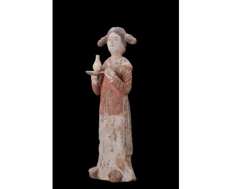 Ca. 618-907 AD. A terracotta figure of standing female attendant standing upright, with a hollow moulded body. The detailing 