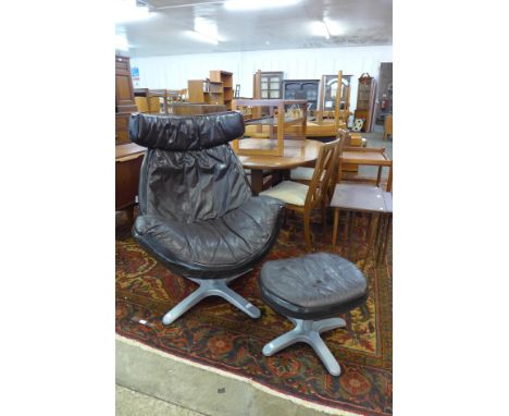A vintage leather revolving lounge chair and stool 