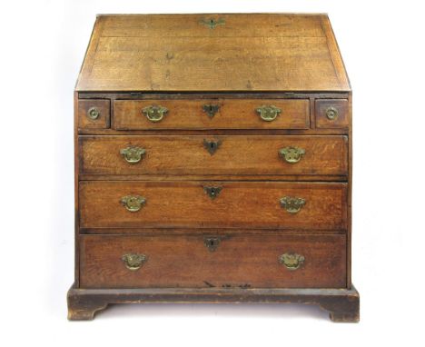 A George III and later oak and crossbanded bureau, the fall front enclosing a fitted interior over an arrangement of two shor