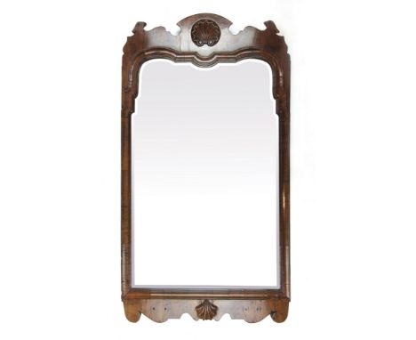 A George I walnut framed bevel glass mirror with recessed shell carving to top flanked by two bird heads, above concave mould