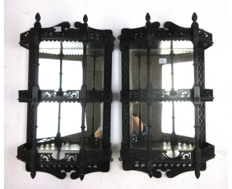 A pair of late Victorian ebonized mirror back wall shelves, with pierced galleries, blind fret back supports and turned front