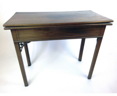 A late 18th century mahogany and banded games table, the fold over top supported on a single gate action, with two drawers to
