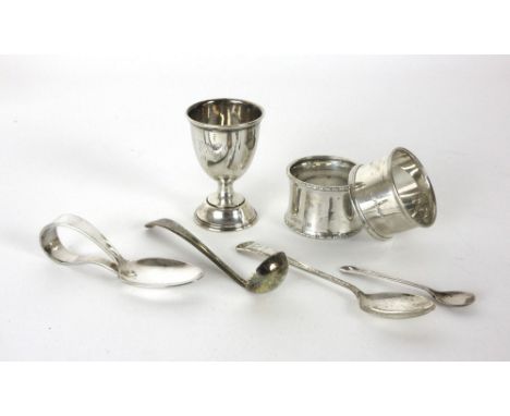 A group of silver including two napkin rings, a small trophy, a small silver gilt ladle and two spoons, overall w. 100 grams,