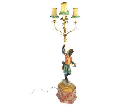 A 20th century floor standing six branch candle lamp, carved in the form of a Blackamoor , 123cm high, raised on a painted si