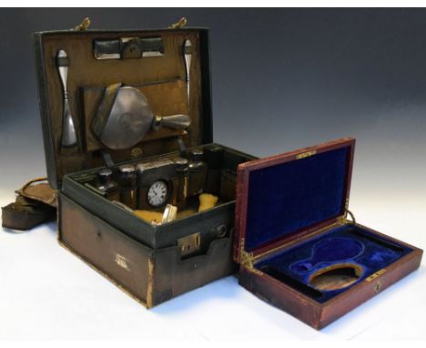 George V gentleman's travelling dressing set in green hide case and canvas cover, the interior opening to reveal silver and g