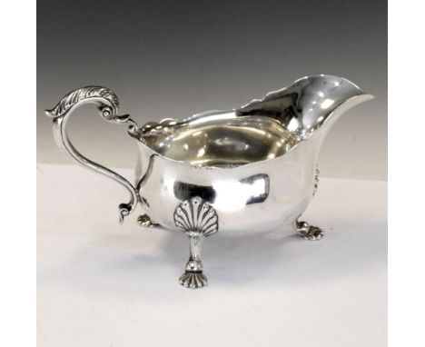 Edward VII silver sauce boat with shaped rim and scroll handle and standing on three shell feet, London 1917, 21cm wide, 375g