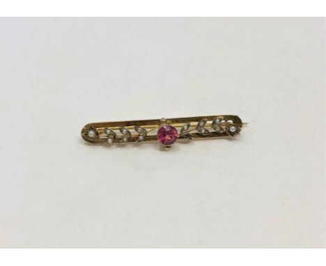 A 9ct gold seed pearl bar brooch set with a ruby coloured stone, 3.6g.