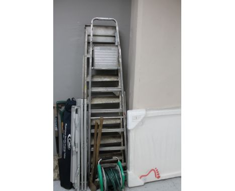 Two metal step ladders together with a quantity of garden tools, aluminium roll up table, two watering cans 