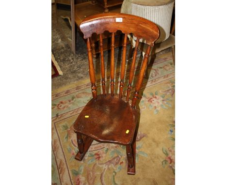 A VINTAGE OAK FARMHOUSE SPINDLED BACK CHILD'S ROCKING CHAIR