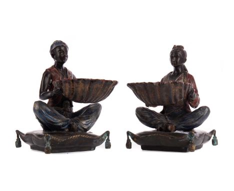 PAIR OF COLD PAINTED BRONZED SERVING DISHES,the bowls modelled as shells supported by seated Oriental figures on cushion base