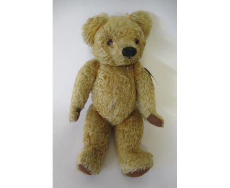 A Chad Valley long haired growling teddy bear, with glass eyes, sewn nose, felt pads and label to foot, 21" long (Est. plus 2