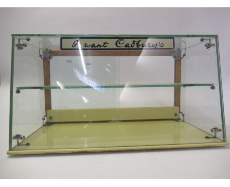 A Cadbury's Chocolate display cabinet, glass construction with one shelf, Cadbury's logo on top, G-E, measures 23 3/4" wide, 