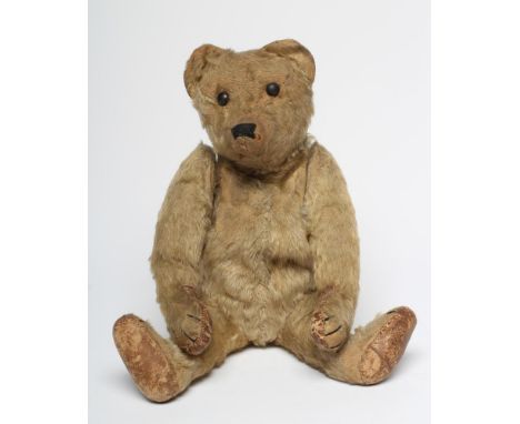 An early German teddy, straw filled, with light orange plush, later sewn nose, button eyes, leather pads, swivel joints and h