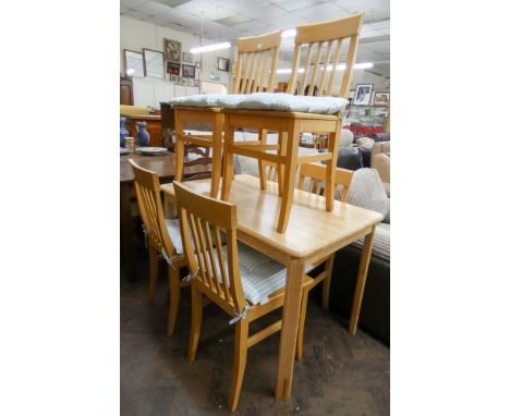 A light beech dining table together with six matching slat backed chairs with gingham seat pads 