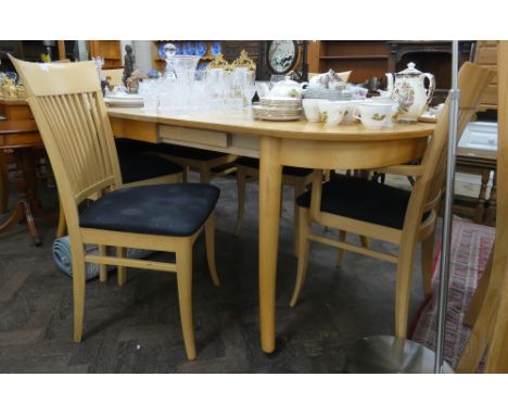 A light beech extending dining table and six matching slat backed chairs 