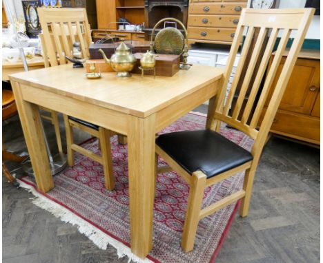 A chunky light oak dining table on square legs 3' square and a pair of matching slat back dining chairs 