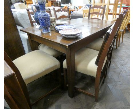 A reproduction oak extending dining table with two leaves and six matching ladder back dining chairs with upholstered seats 