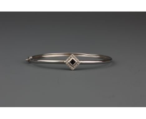 A 9ct white gold stone set bangle, L. 6cm.