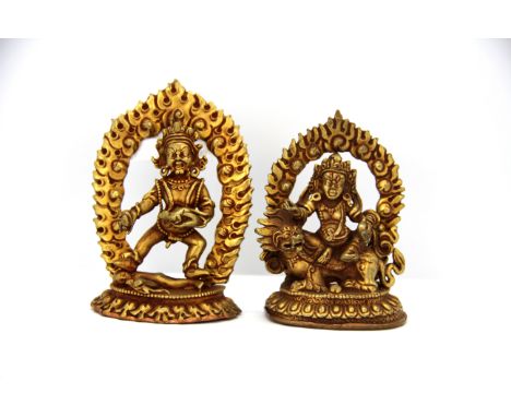 Two small Tibetan gilt bronze figures of Buddhist Deities with detachable flame backgrounds, tallest 9cm.